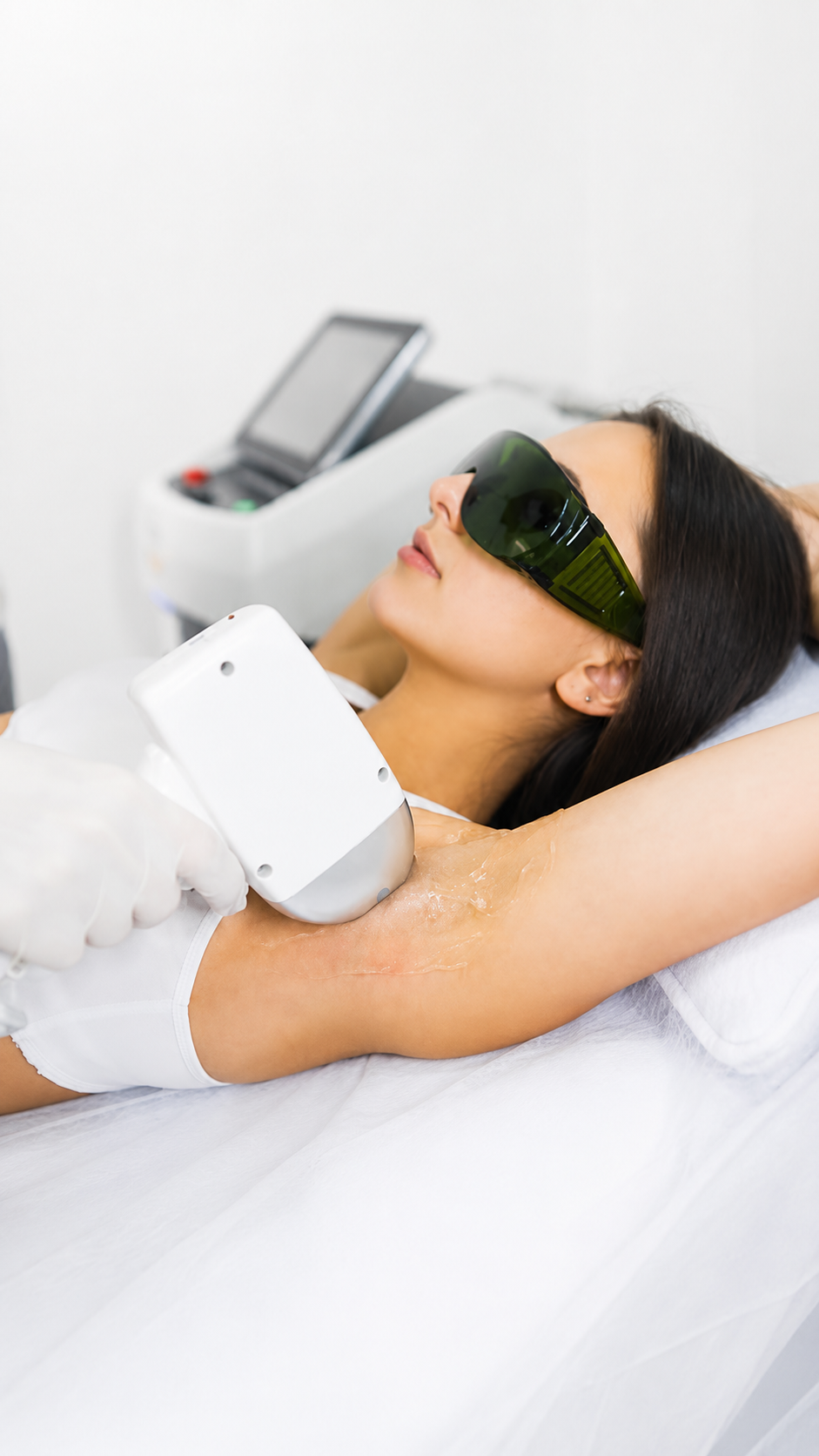 Practitioner performing laser hair removal on patient's arm